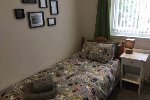 a bedroom with a bed and a table with a lamp at Blarmore Apartment Inverness in Inverness