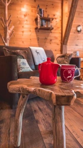 a wooden table with a red tea pot on it at Chalet Harmonie in Inzell