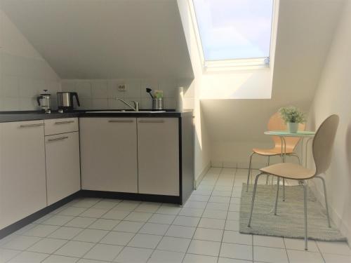 een keuken met een wastafel en een tafel met stoelen bij Zwillingsperlen Leutzsch – Appartement Reiterhof in Leipzig