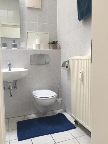 een badkamer met een toilet en een wastafel bij Zwillingsperlen Leutzsch – Appartement Reiterhof in Leipzig