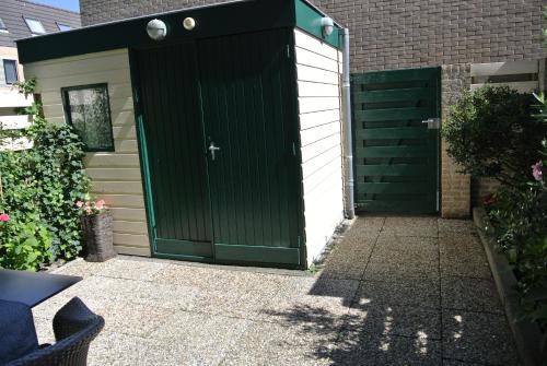 a garage with a green door on a house at Yuki in Zandvoort