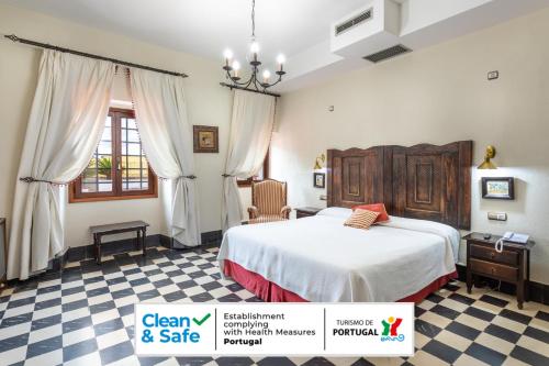a bedroom with a bed and a checkered floor at Hotel Sao Joao De Deus by RIDAN Hotels in Elvas