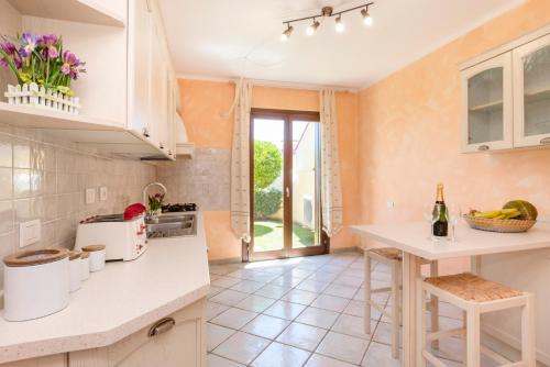 una cocina con encimera y una mesa con flores en Villaggio Turchese, en Murta Maria