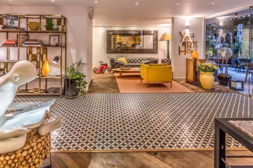 a living room with a couch and a yellow chair at Jacob Shenkin Hotel in Tel Aviv