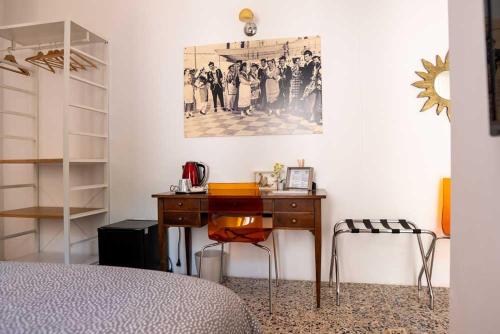 - une chambre avec un bureau et une photo sur le mur dans l'établissement Maddrigga di Luna, à Selargius