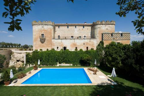 einen Blick auf ein Schloss mit Pool in der Unterkunft Posada Real Castillo del Buen Amor in Villanueva de Cañedo