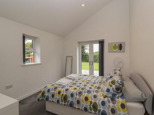 um quarto branco com uma cama e um sofá em Cartrefle Fach em Pentraeth