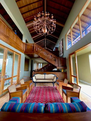 a living room with a chandelier and a red rug at Atulya Villas Nuwara Eliya in Nuwara Eliya