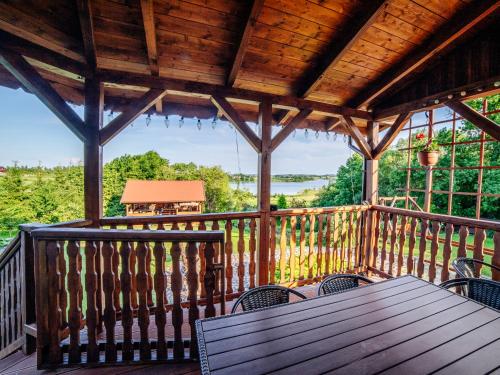 a wooden deck with a table and chairs on it at Gospodarstwo Agroturystyczne Rowerowa Przystań "Jankesówka" in Lidzbark Warmiński