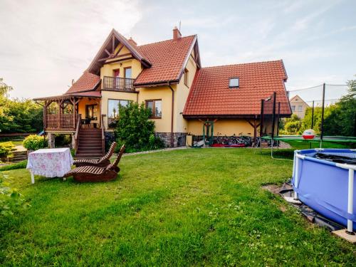a house with a yard with a swing at Gospodarstwo Agroturystyczne Rowerowa Przystań "Jankesówka" in Lidzbark Warmiński