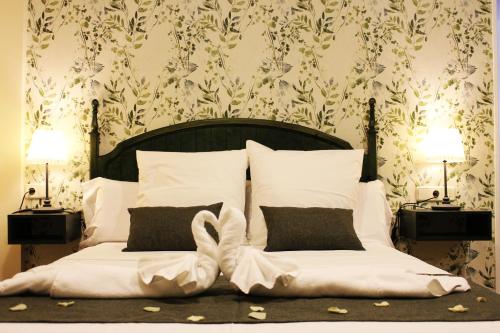 a bedroom with a bed with white pillows and two lamps at Hotel Rural Molino del Albaicín in Sabiote