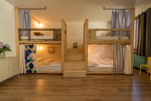 2 Etagenbetten in einem Zimmer mit Holzböden in der Unterkunft Ostello Antagonisti in Melle