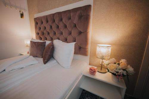 a bedroom with a bed with a headboard and a lamp at Hotel Marabella in Sibiu