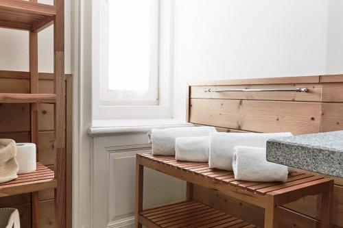 a pile of towels sitting on a shelf in a bathroom at Maloja Palace Residence Engadin-St Moritz CO2-Neutral in Maloja