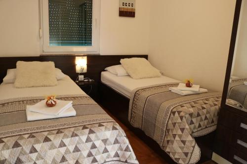 a room with two beds with towels and a mirror at Apartments Marina in Vodice