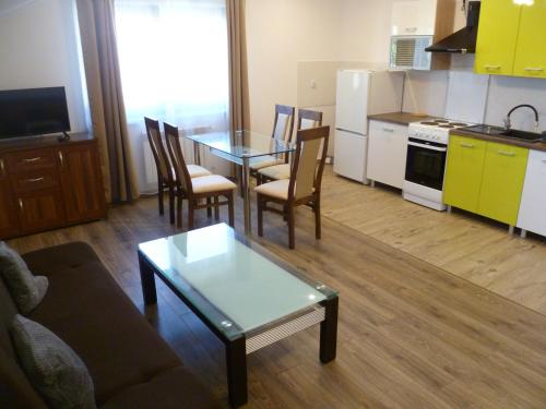 a living room with a table and a kitchen at Klimatyczny Domek - Apartamenty & Noclegi in Sławęcin