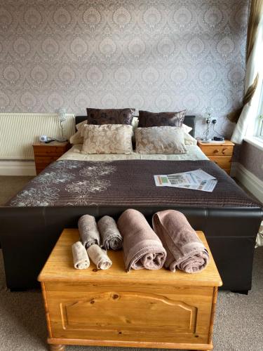 a bed with rolled towels on a wooden box at The Fairmile in Lytham St Annes