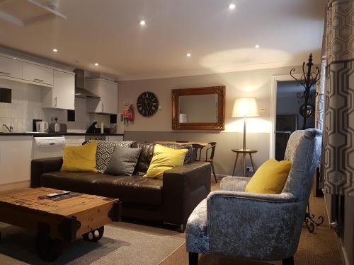 a living room with a couch and a chair and a table at The Windmill in Scarborough