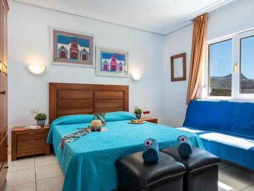 una camera con un letto blu e un divano di 10E Country Club Accommodation POOL! ad Arona