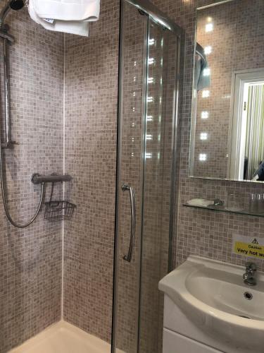 a bathroom with a shower and a sink at The Mowbray in Eastbourne