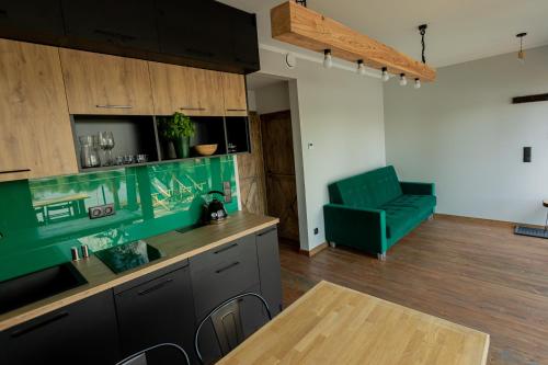 een woonkamer met een tafel en een groene bank bij Weź tu Przystań in Pomiechówek