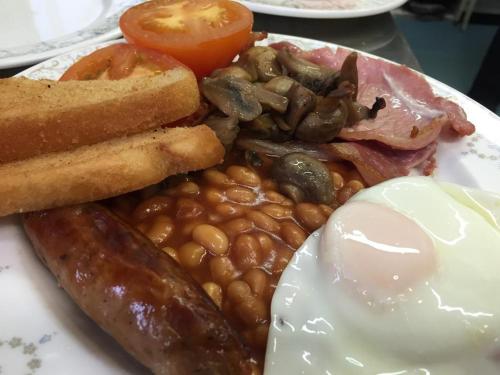 a plate of food with eggs sausage beans and bread at The Mowbray in Eastbourne
