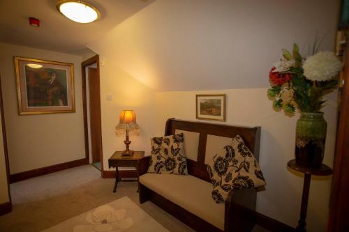 a living room with a couch and a vase of flowers at Springburn Farmhouse in Spean Bridge