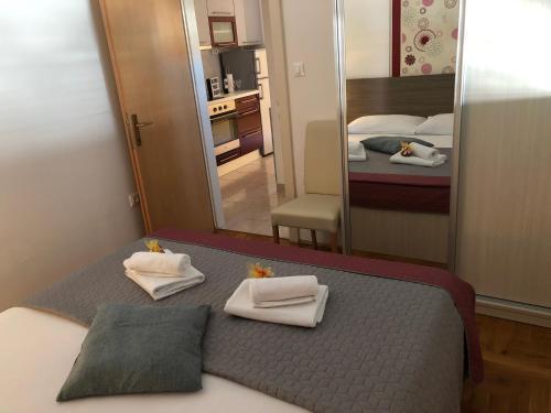 - une chambre avec un lit, des serviettes et un miroir dans l'établissement Apartments Marina, à Vodice