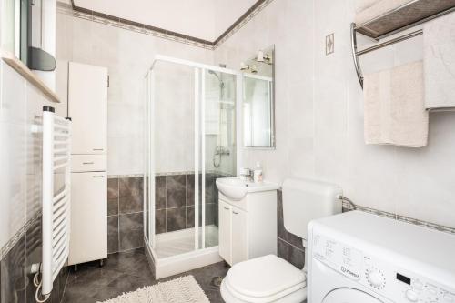 une salle de bain blanche avec toilettes et douche dans l'établissement SeaView Studio, à Umag
