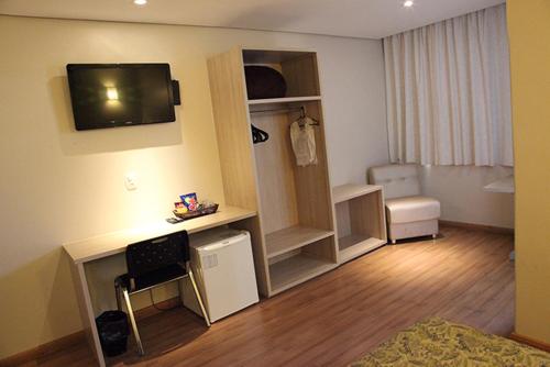 a small living room with a room with a television and a room at Golden Hotel - O MAIS CENTRAL - Pet Friendly in Chapecó