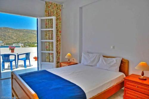 a bedroom with a bed and a balcony with a table at Saint Nicholas Katapola in Katapola