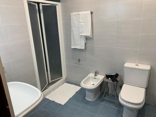 a white bathroom with a toilet and a sink at Apartamento Salomé in Padrón