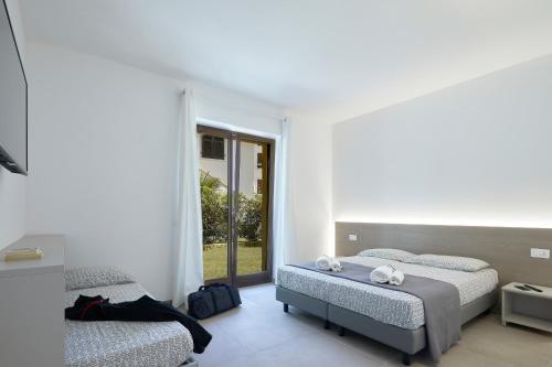 sypialnia z 2 łóżkami i oknem w obiekcie Agriturismo De Bas w mieście Riva del Garda