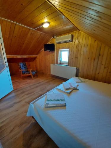 a bedroom with a white bed in a wooden cabin at Casa Atlas in Eforie Sud