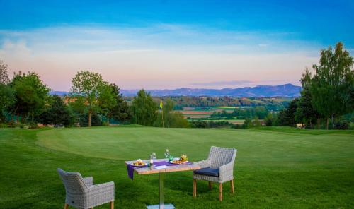 a table and two chairs on a green field at OG's Golf Lodge in Kematen an der Krems