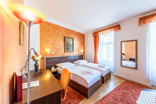 een hotelkamer met 2 bedden en een bureau bij Hotel Trumf in Mladá Boleslav