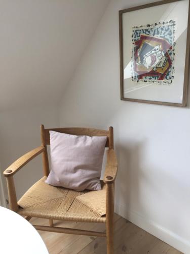 a wooden chair with a pillow in a room at Birgittes B&B i Jelling in Jelling