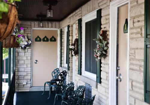 a front porch with chairs and a door at Simmons Motel and Suites in Hershey