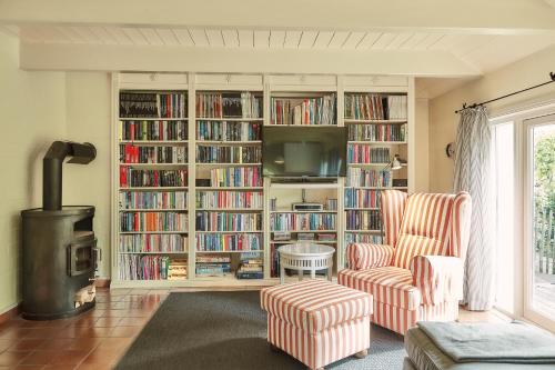 a living room with a book shelf filled with books at Föhrienhaus in Midlum