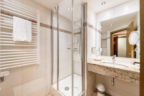 ein Bad mit einer Dusche und einem Waschbecken in der Unterkunft Göbels Hotel zum Löwen in Friedewald