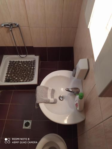 y baño con lavabo blanco y ducha. en Morfili Villa en Limenaria