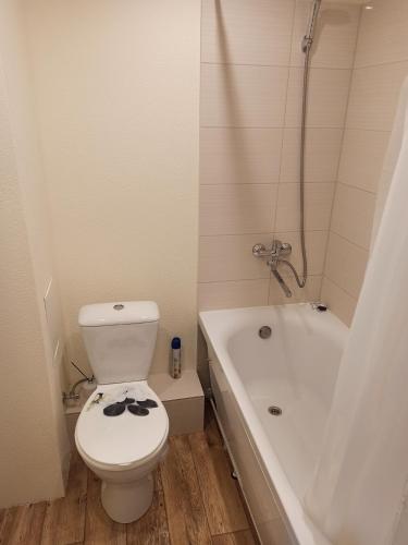 un baño con inodoro y bañera en Inzenieru 75 Apartments, en Ventspils