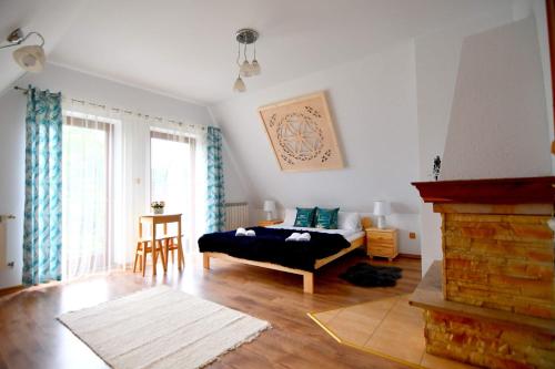 a living room with a bed and a fireplace at Zakątek u Pary in Biały Dunajec