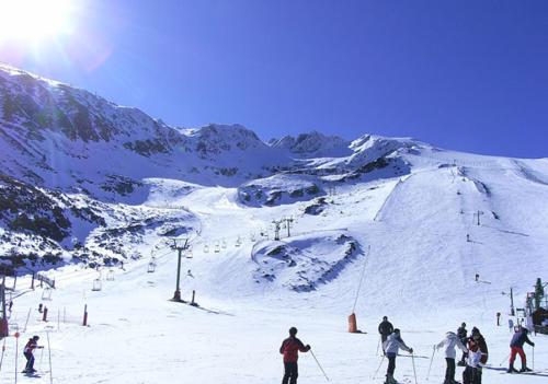 a group of people skiing on a snow covered mountain at Albergue Centro de Ocio Luis Miguel in Fresno de la Fuente