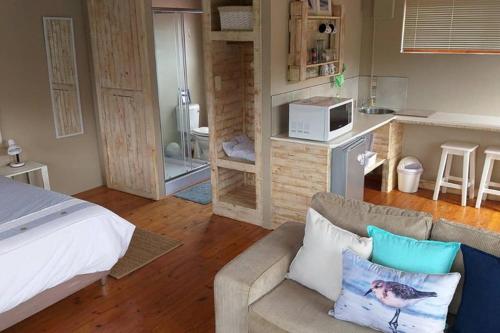 ein Schlafzimmer mit einem Bett und einem Sofa sowie eine Küche in der Unterkunft Whale of a Time - Sedgefield in Sedgefield
