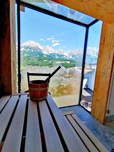 a bucket sitting on a bench in front of a window at Hotel Hochfilzer in Ellmau