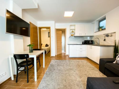 a kitchen and living room with a table and a couch at Lakeview Villa Bled in Bled