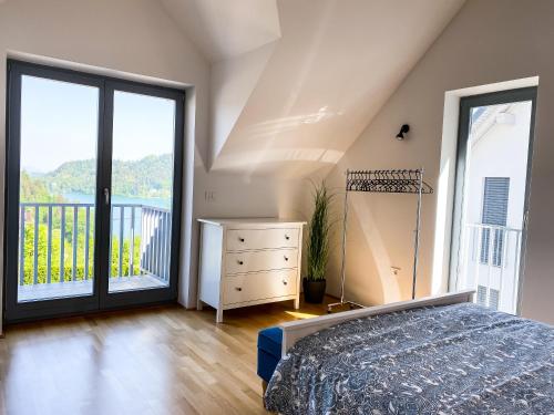 a bedroom with a bed and a balcony at Lakeview Villa Bled in Bled