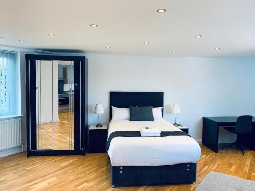 a bedroom with a bed and a desk and a mirror at Greenwich Stay in London