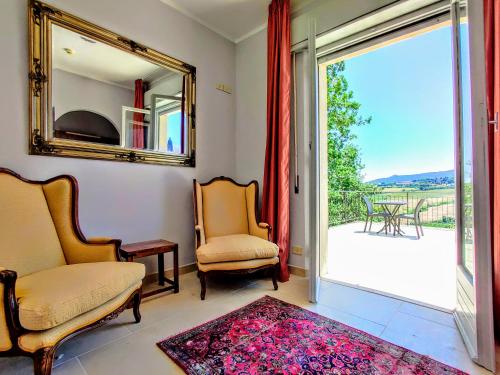 a living room with two chairs and a mirror at Arts Club Suite & Spa in Chianciano Terme